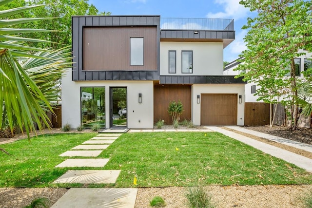 view of front of property featuring a front yard and a garage