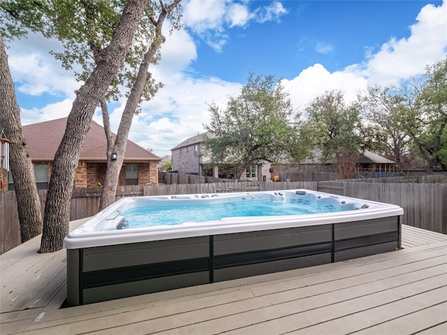 view of swimming pool with an outdoor hot tub and a deck