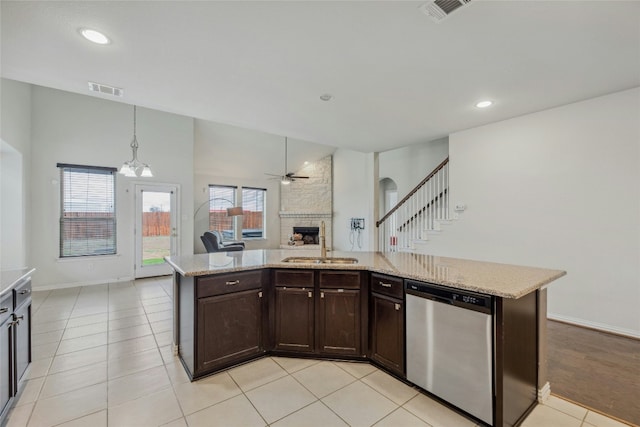 kitchen featuring a kitchen island with sink, a sink, visible vents, open floor plan, and dishwasher