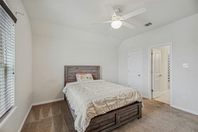 carpeted bedroom with a ceiling fan, lofted ceiling, visible vents, and baseboards