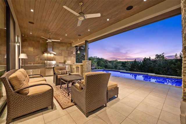702 Crystal Mountain Dr, Austin, TX 78733 - patio terrace at dusk featuring exterior kitchen, ceiling fan, an outdoor pool, a patio area, and an outdoor hangout area