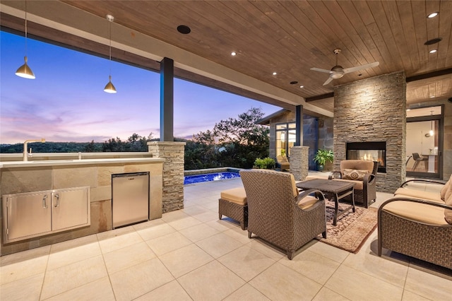 702 Crystal Mountain Dr, Austin, TX 78733 - view of patio with an outdoor kitchen, an outdoor pool, a ceiling fan, and an outdoor living space with a fireplace
