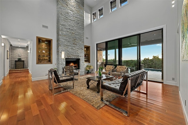 702 Crystal Mountain Dr, Austin, TX 78733 - living area featuring a fireplace, a towering ceiling, plenty of natural light, and wood finished floors