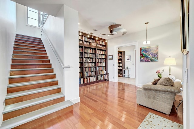 702 Crystal Mountain Dr, Austin, TX 78733 - staircase with wood finished floors and built in shelves