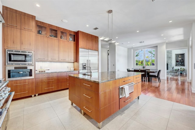 702 Crystal Mountain Dr, Austin, TX 78733 - kitchen with built in appliances, a warming drawer, modern cabinets, light stone countertops, and light tile patterned flooring