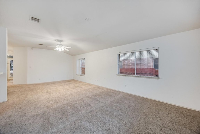 carpeted empty room featuring ceiling fan and vaulted ceiling