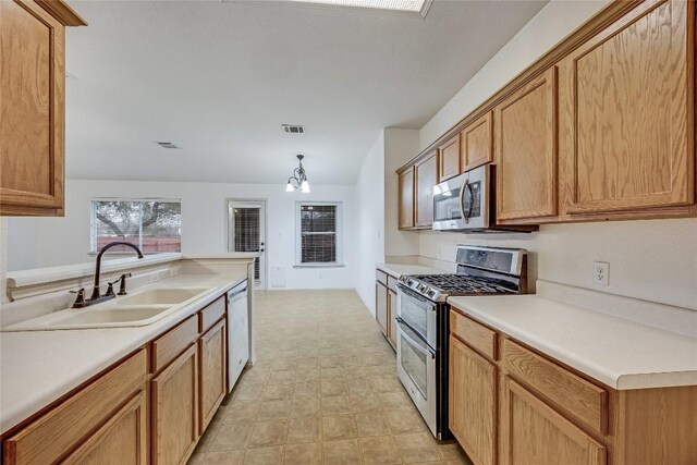 3580 Rock Shelf Ln, Round Rock, TX 78681 - kitchen with appliances with stainless steel finishes, a chandelier, light countertops, decorative light fixtures, and brown cabinets