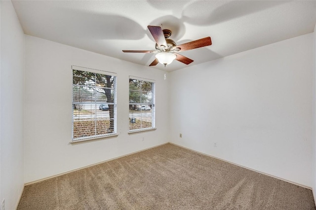 carpeted spare room featuring ceiling fan