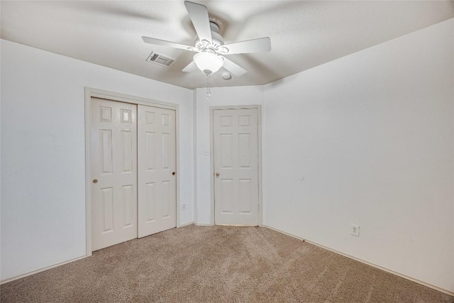 unfurnished bedroom with carpet floors, a closet, and ceiling fan