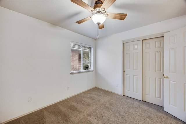 unfurnished bedroom featuring ceiling fan, carpet flooring, and a closet