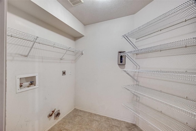 washroom with washer hookup, hookup for a gas dryer, hookup for an electric dryer, and a textured ceiling