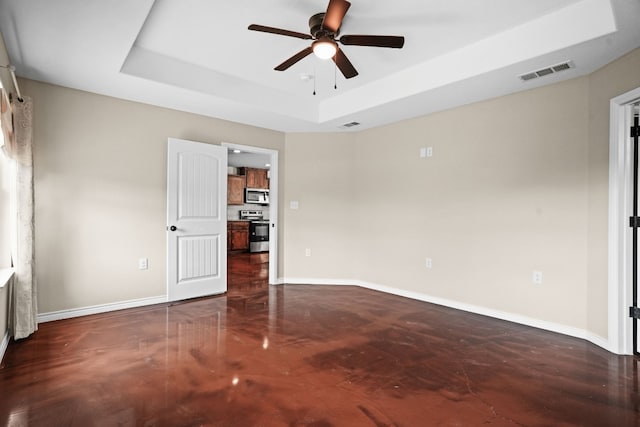 unfurnished bedroom featuring ceiling fan and a tray ceiling