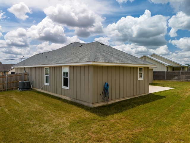 back of property with a lawn and central AC