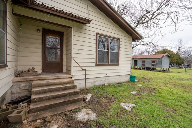 view of exterior entry with a lawn