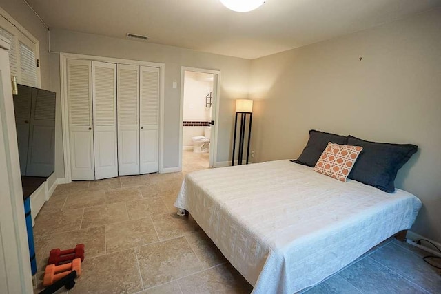 3610 Branigan Ln, Austin, TX 78759 - bedroom featuring stone finish flooring, connected bathroom, and a closet