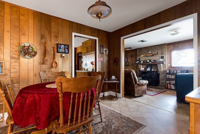 dining room featuring a wood stove and wooden walls