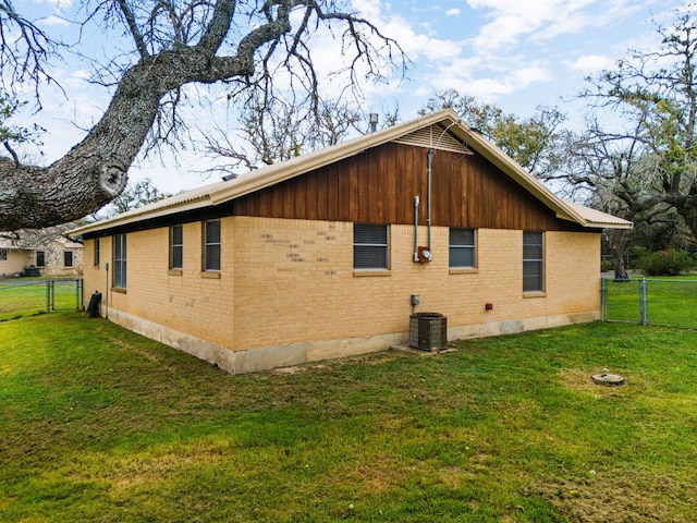 view of home's exterior with a lawn and central AC