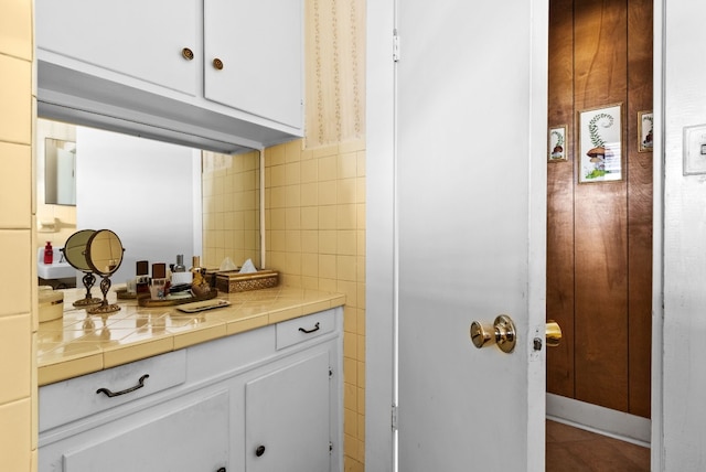 kitchen featuring tile walls, white cabinets, and tile counters