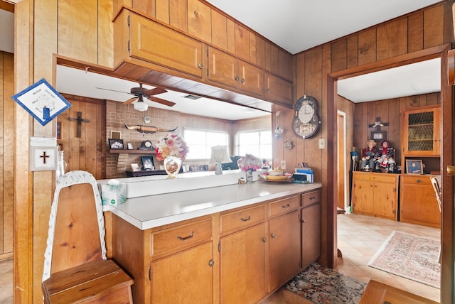 kitchen featuring ceiling fan and wooden walls