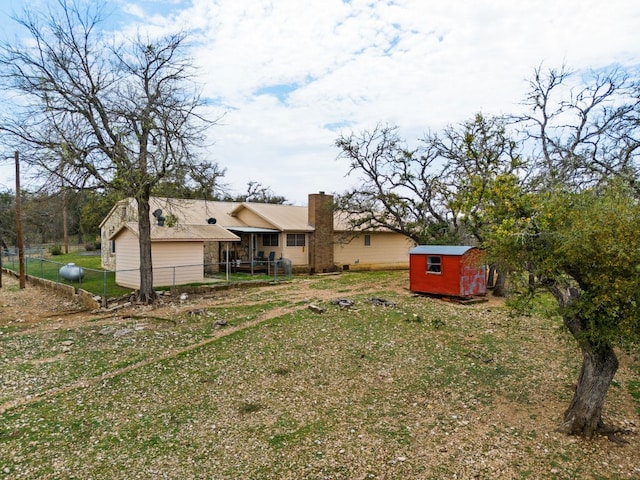 rear view of property featuring a yard and a shed