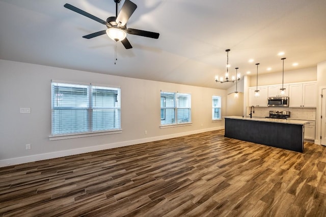 kitchen featuring white cabinetry, a kitchen island with sink, stainless steel appliances, decorative light fixtures, and sink