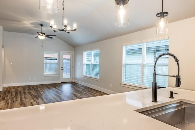 kitchen with lofted ceiling, pendant lighting, a sink, and dark wood-style flooring