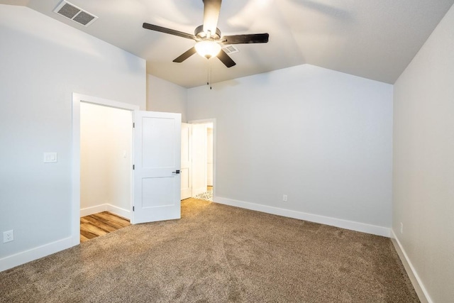 unfurnished bedroom with lofted ceiling, visible vents, light carpet, and baseboards