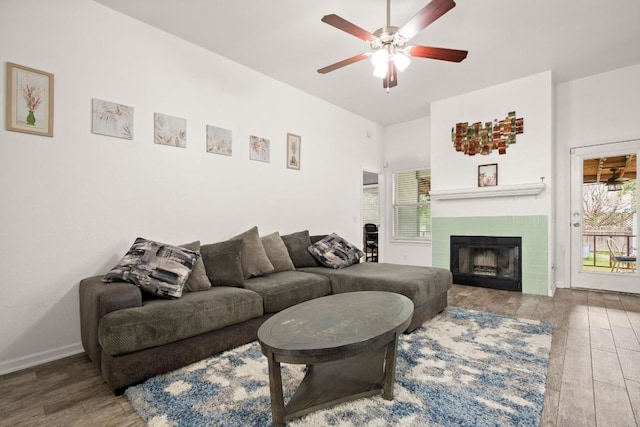 living room featuring ceiling fan, a tile fireplace, hardwood / wood-style floors, and a healthy amount of sunlight