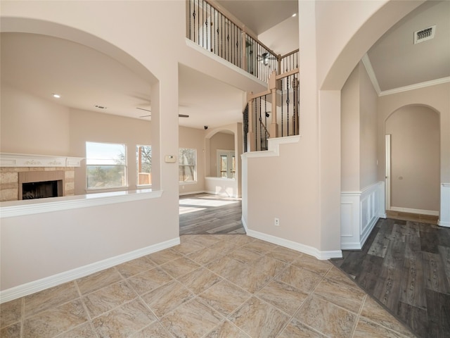 interior space featuring hardwood / wood-style flooring, a high ceiling, and ornamental molding