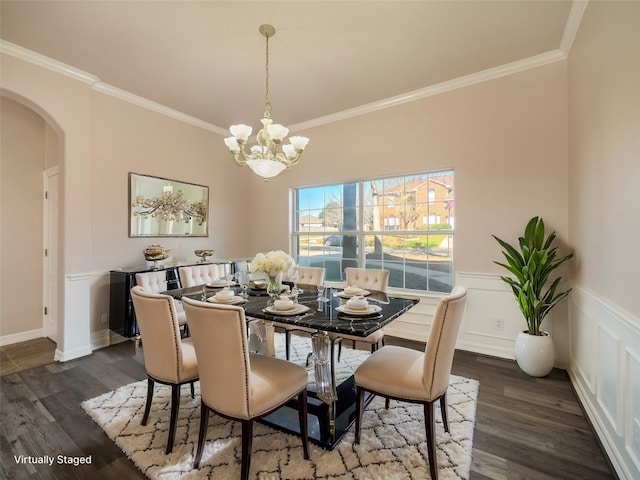 dining space with ornamental molding, dark wood-type flooring, and an inviting chandelier