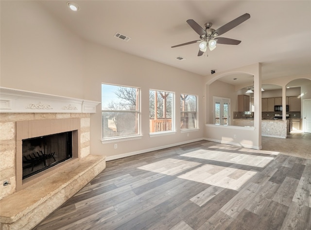 unfurnished living room featuring a fireplace, ceiling fan, and wood-type flooring