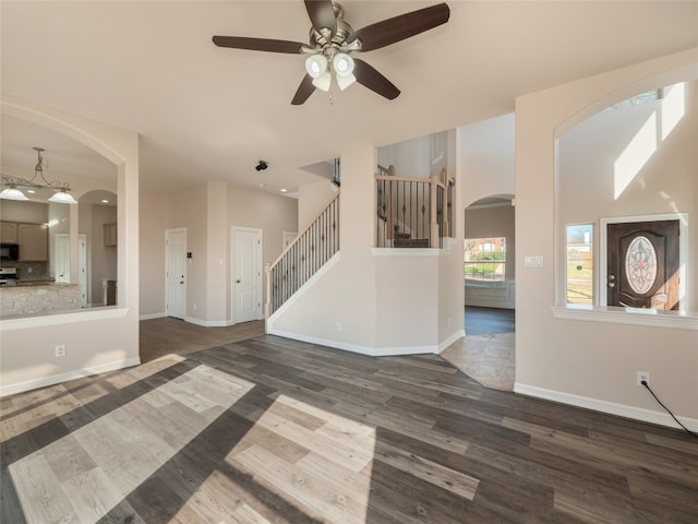 unfurnished living room featuring ceiling fan and dark hardwood / wood-style flooring