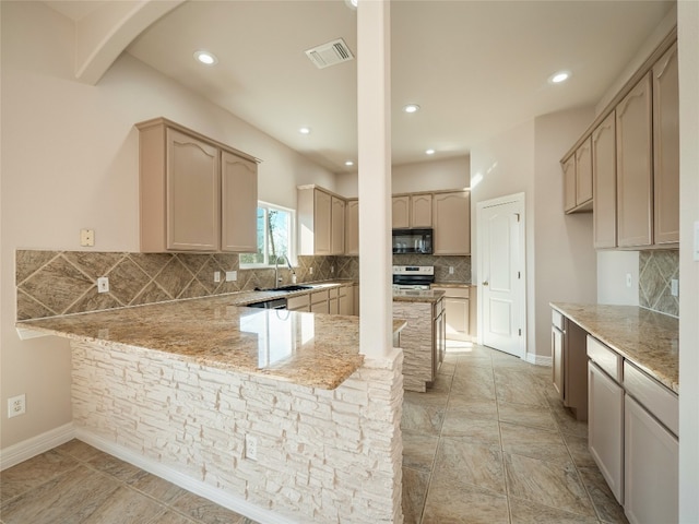 kitchen featuring light brown cabinetry, light stone counters, decorative backsplash, sink, and kitchen peninsula