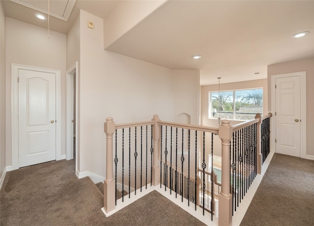 hall with dark colored carpet