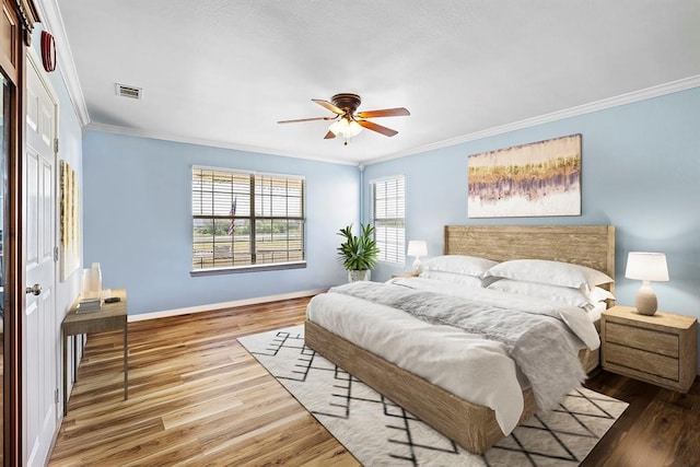 bedroom featuring hardwood / wood-style floors, ceiling fan, a closet, and crown molding