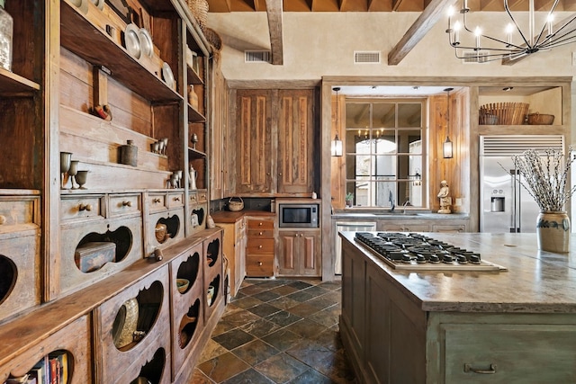 kitchen with built in appliances, a notable chandelier, visible vents, and decorative light fixtures