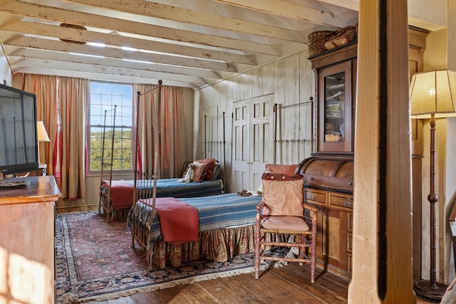 bedroom featuring beam ceiling and wood finished floors