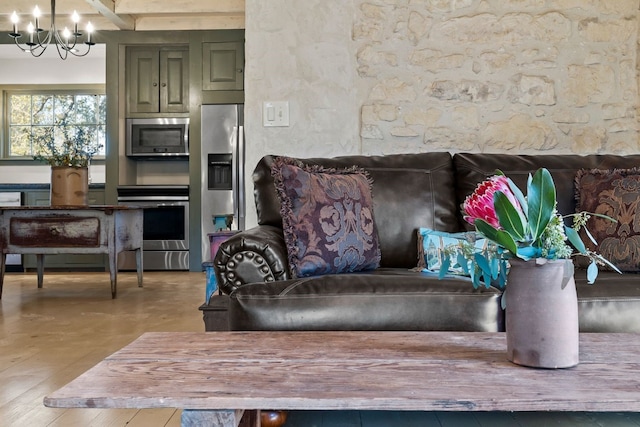 interior space with green cabinets, hanging light fixtures, appliances with stainless steel finishes, and a chandelier