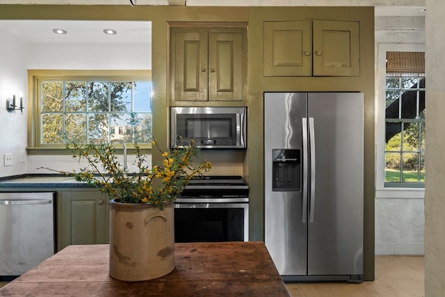 kitchen featuring dark countertops, light wood-style flooring, appliances with stainless steel finishes, and recessed lighting