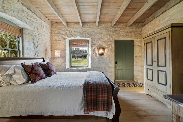 bedroom featuring wood ceiling, beamed ceiling, and wood finished floors