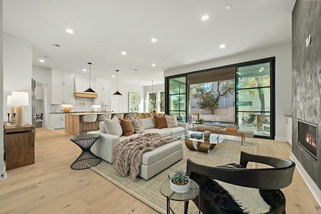 living room with a large fireplace and light hardwood / wood-style floors