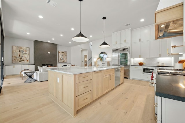 1339 Allen Rd, Austin, TX 78746 - kitchen featuring built in appliances, light wood-style floors, wall chimney exhaust hood, backsplash, and recessed lighting