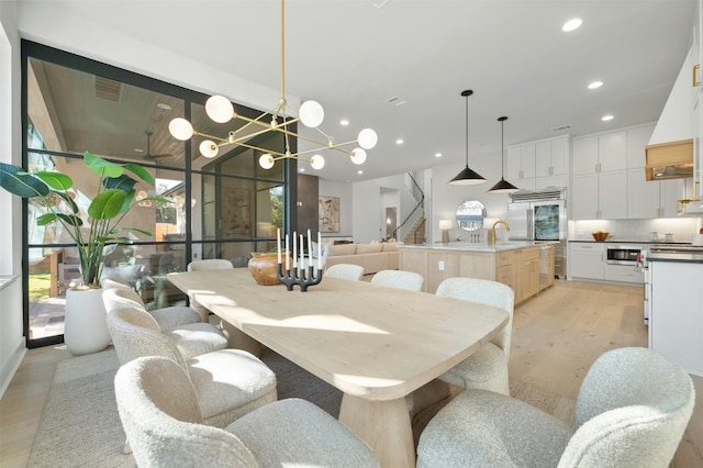 dining space featuring light hardwood / wood-style floors and a notable chandelier