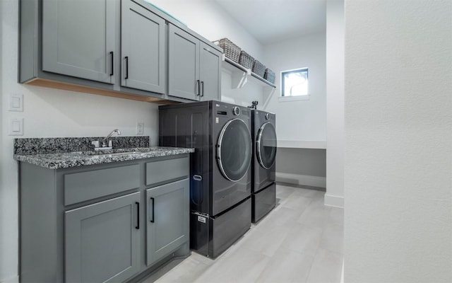 laundry room featuring cabinets, sink, and separate washer and dryer