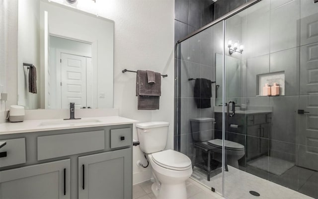 bathroom featuring tile patterned floors, vanity, toilet, and a shower with door