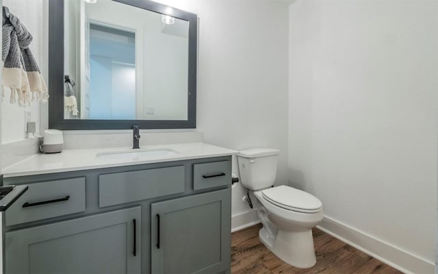 bathroom featuring toilet, vanity, and hardwood / wood-style floors