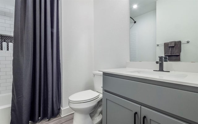 full bathroom featuring wood-type flooring, vanity, shower / tub combo with curtain, and toilet