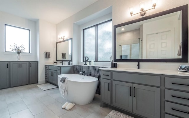 5408 Destination Way, Jonestown, TX 78645 - full bath featuring a shower stall, two vanities, a soaking tub, and tile patterned flooring