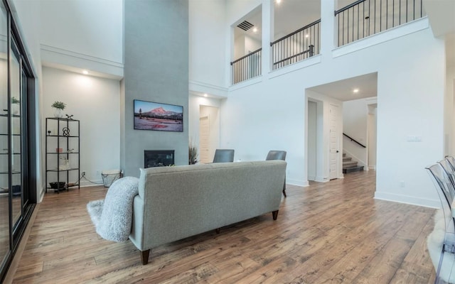 5408 Destination Way, Jonestown, TX 78645 - living area with a fireplace, stairs, wood finished floors, and a towering ceiling
