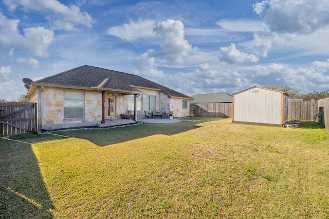 rear view of house with a lawn, a patio, a fenced backyard, an outbuilding, and a storage unit